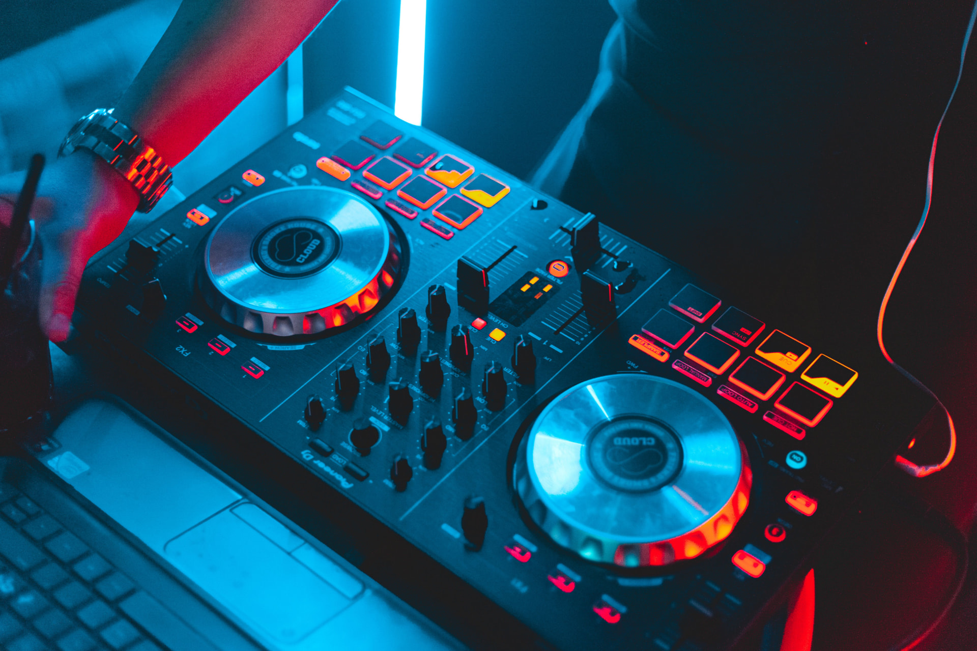 Artist performing behind a glowing DJ controller at a label showcase